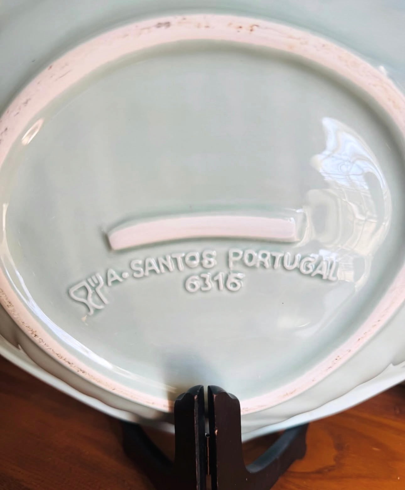 Ceramic plate with 'Pa Santos Portugal 6316' branding on a wooden surface