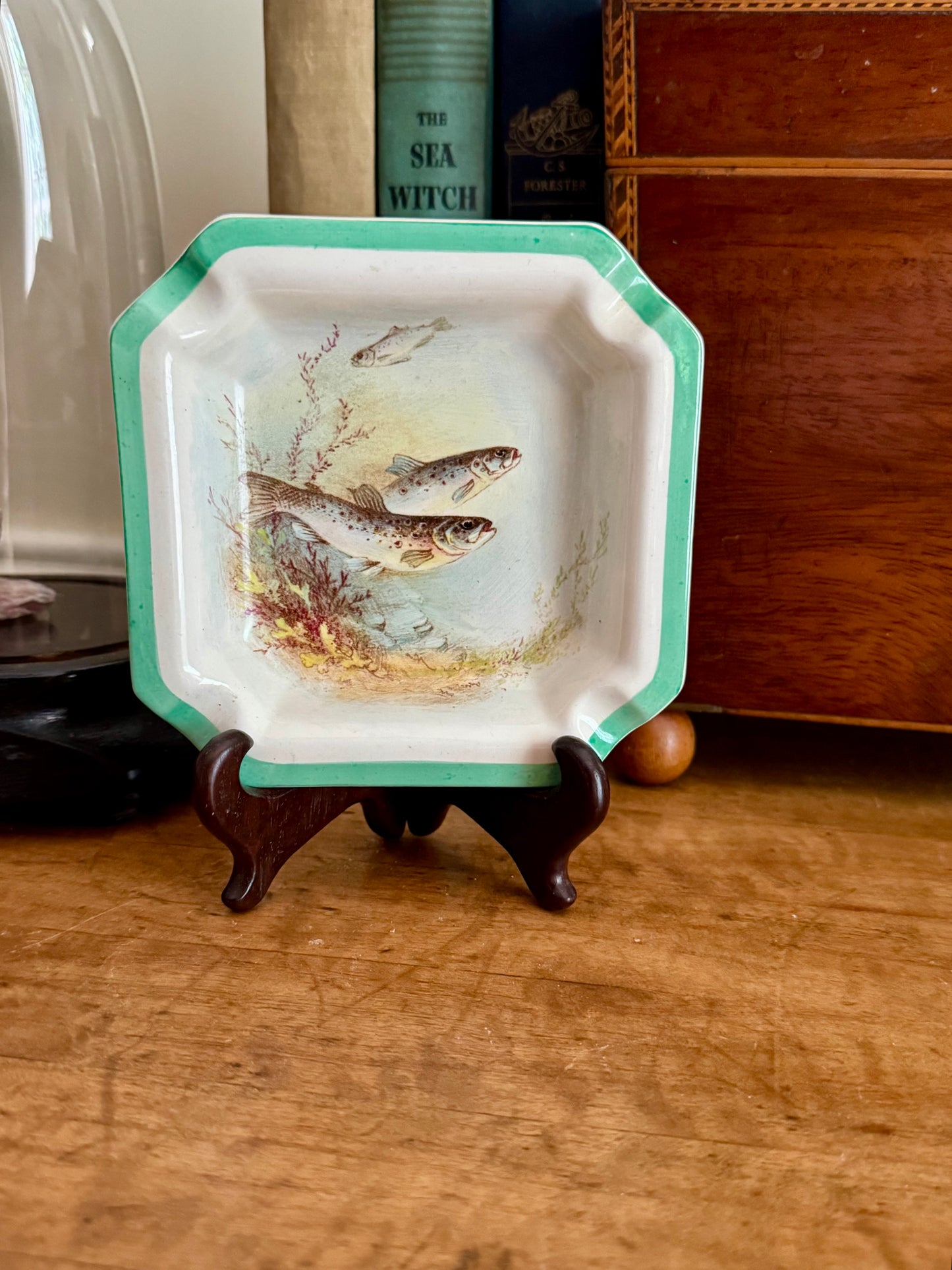 Decorative plate with fish design on a wooden stand