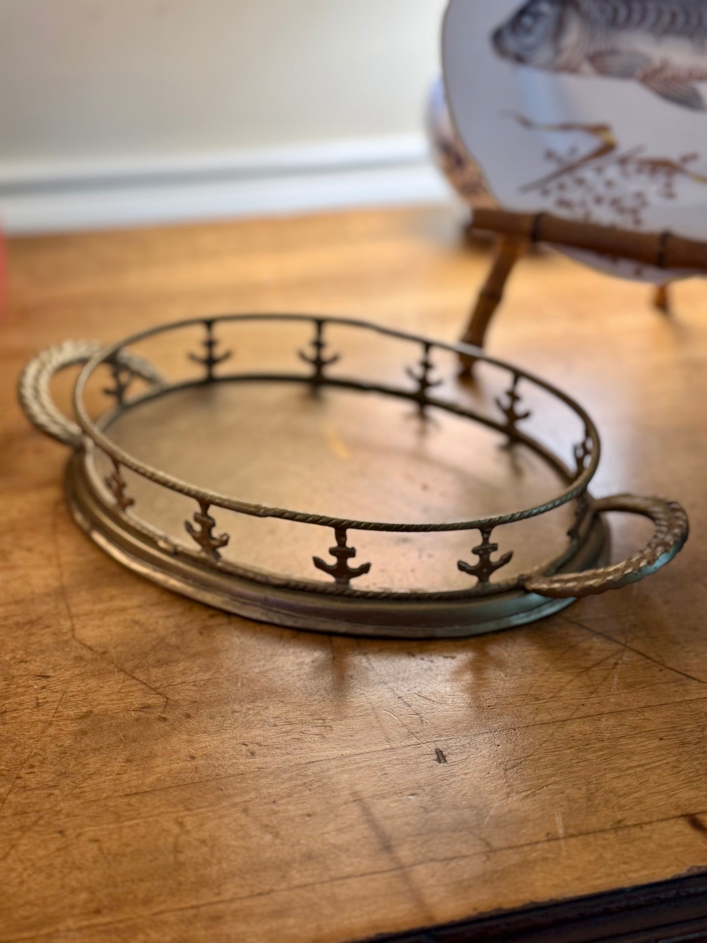 Decorative metal tray with anchor design on a wooden surface