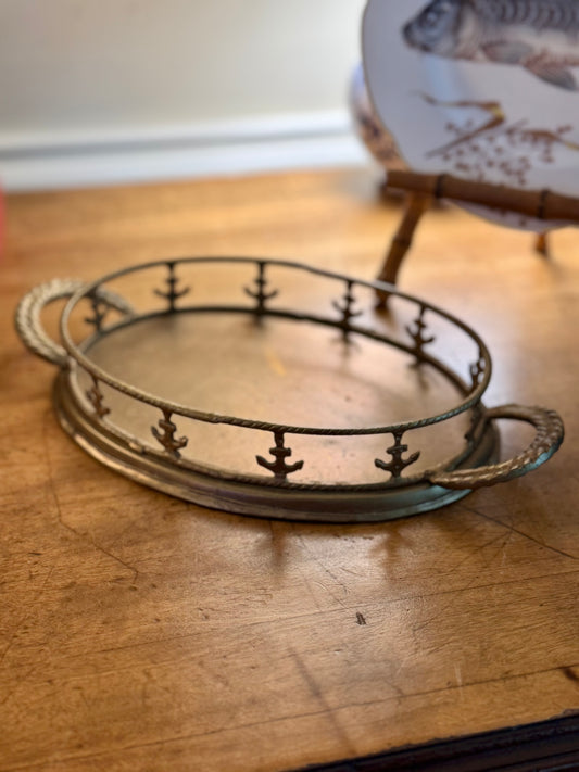Decorative metal tray with anchor design on a wooden surface