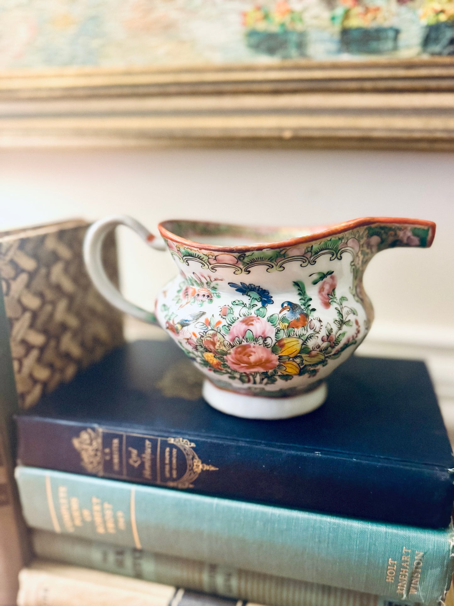 Decorative ceramic cup with floral patterns on a stack of books