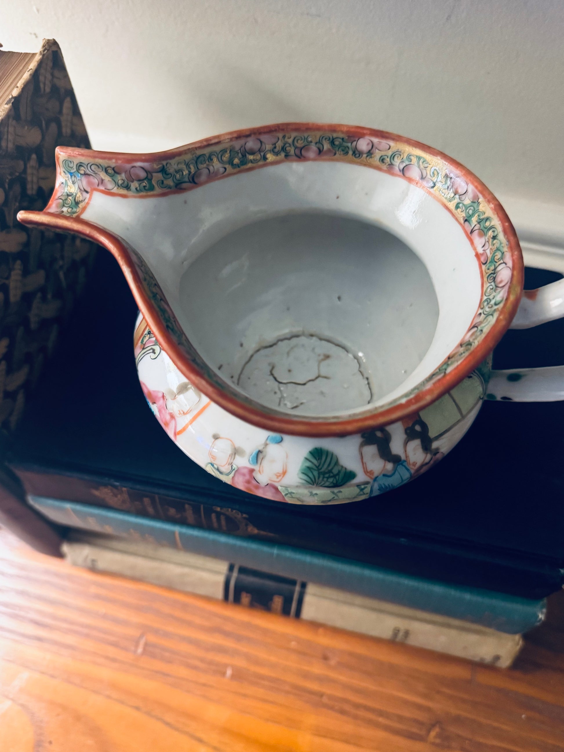 Decorative ceramic item with colorful patterns on a stack of books