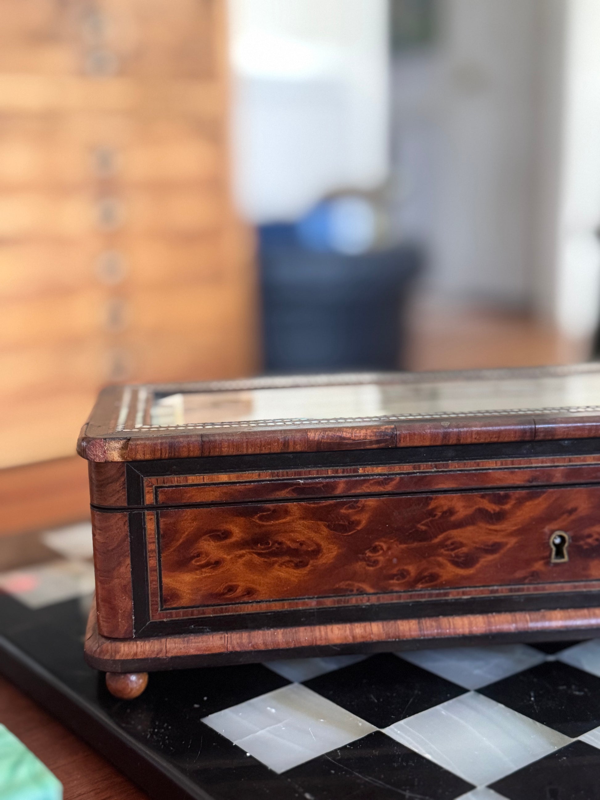 Wooden jewelry box with intricate design on a checkered surface