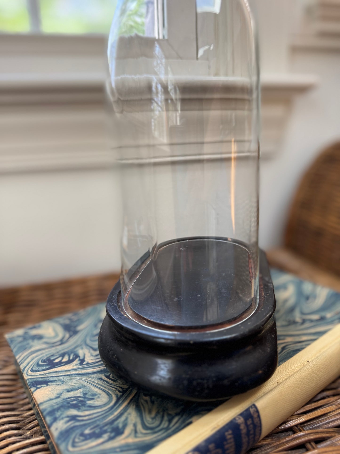 Clear glass container with black base on a textured surface